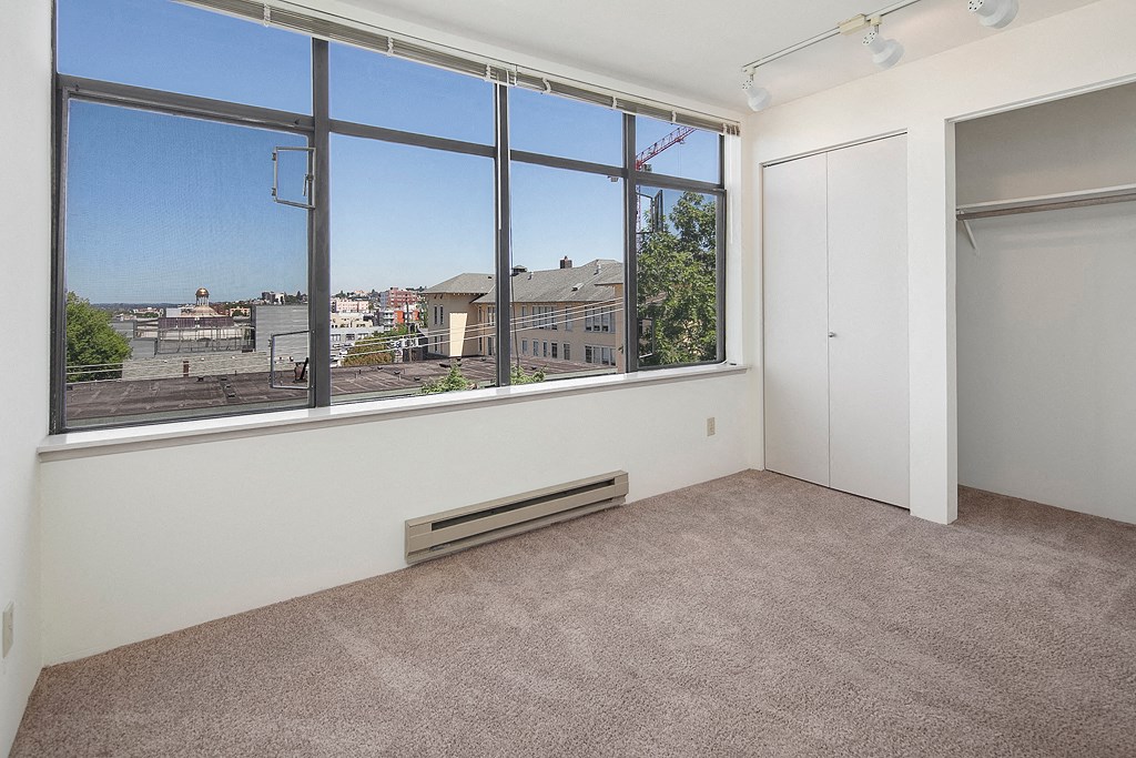 an empty room with a large window and a closet