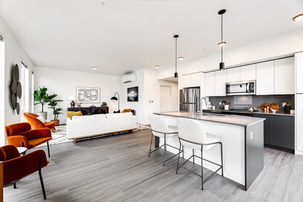 a kitchen and living room with white walls and a white counter top