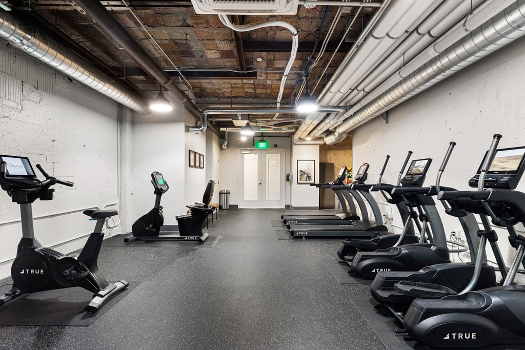 a room filled with lots of cardio equipment and weights