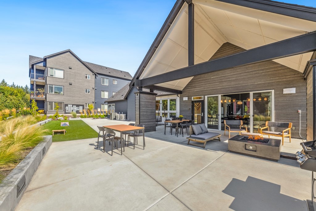 a large patio with tables and chairs and a fire pit
