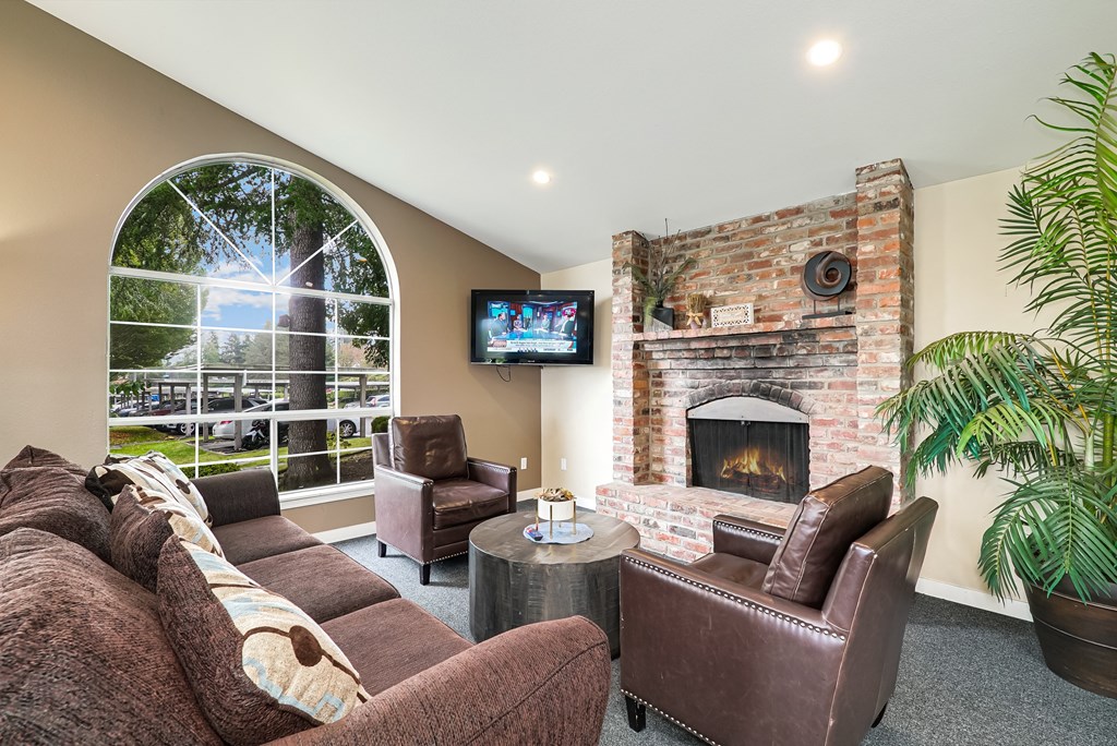 a living room with couches and a fireplace and a tv