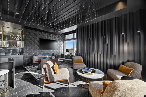 a lounge area with chairs and tables and a television