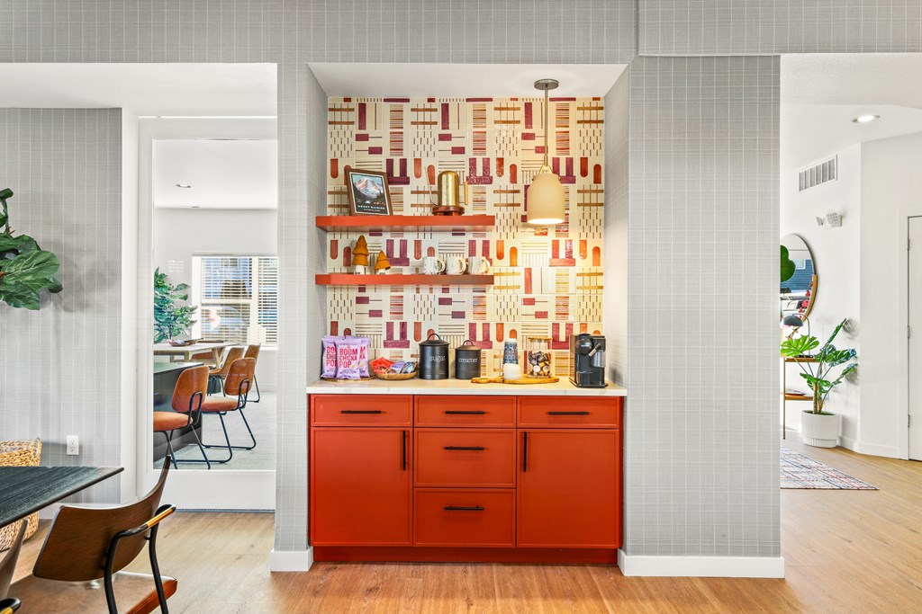 a kitchen with an orange counter and a wall covered in books