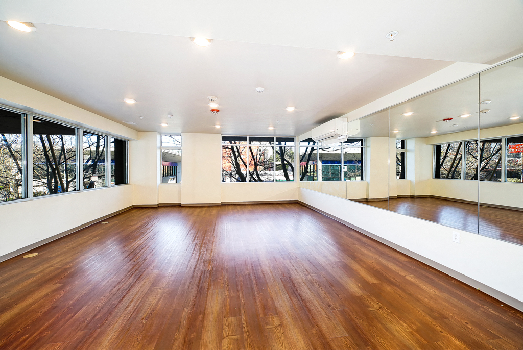 an empty room with a hard wood floor and large windows