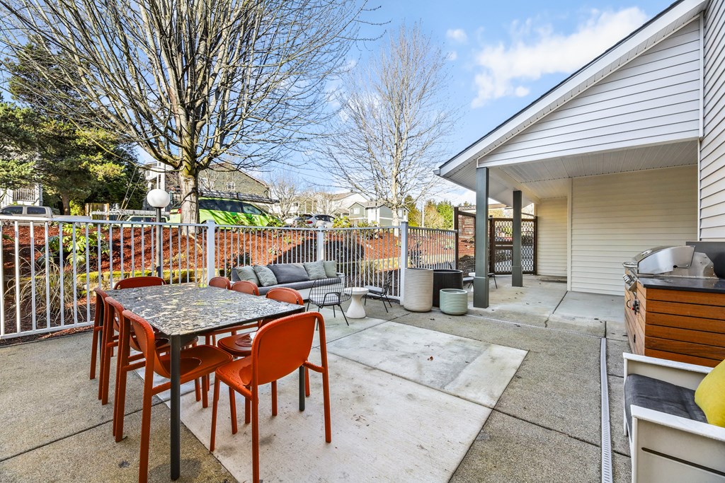 a patio with a table and chairs next to a house