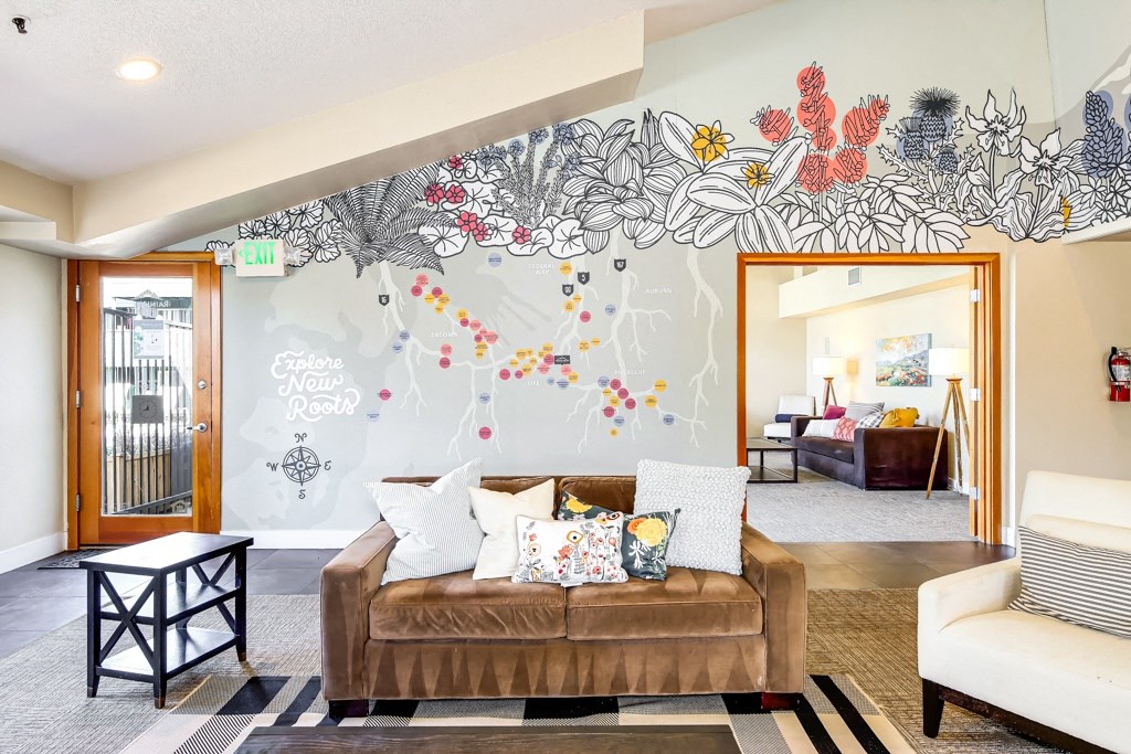 a living room with a couch and a mural on the wall
