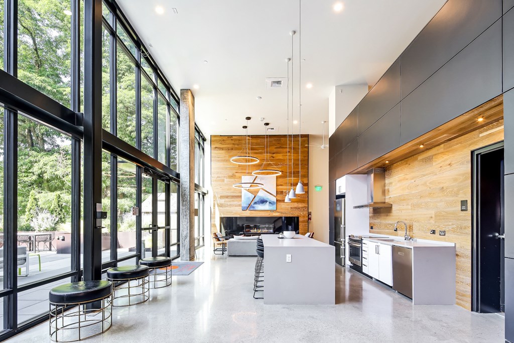 the kitchen and living room of a modern house with large windows and a large island