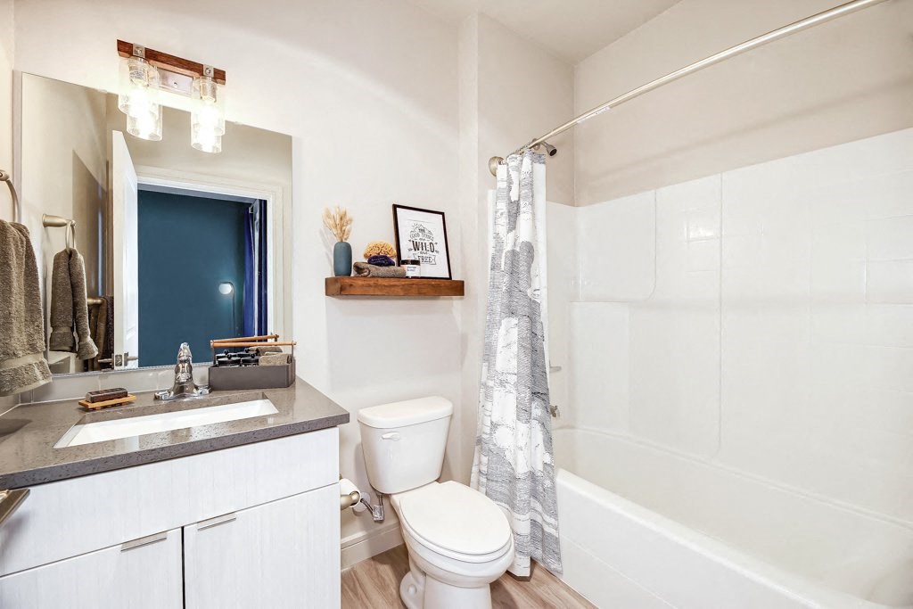 a bathroom with a toilet and a shower and a sink