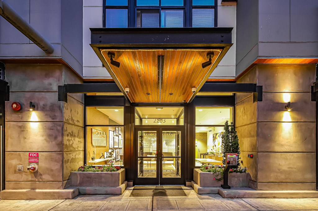 The entrance to a building with a wooden canopy and glass doors.