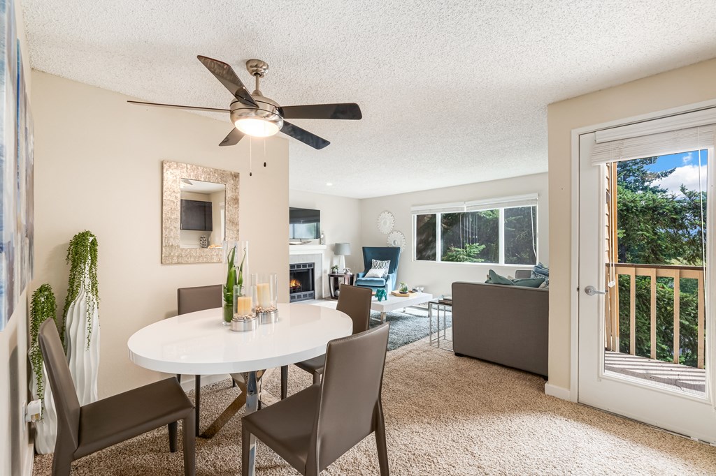 a dining room with a white table and chairs and a ceiling fan