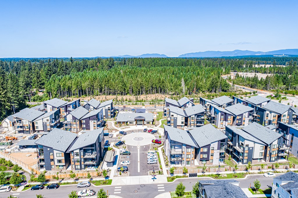 an aerial view of an apartment complex with trees in the background