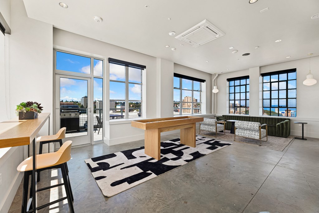a living room with a large window and a wooden table in the middle of the room