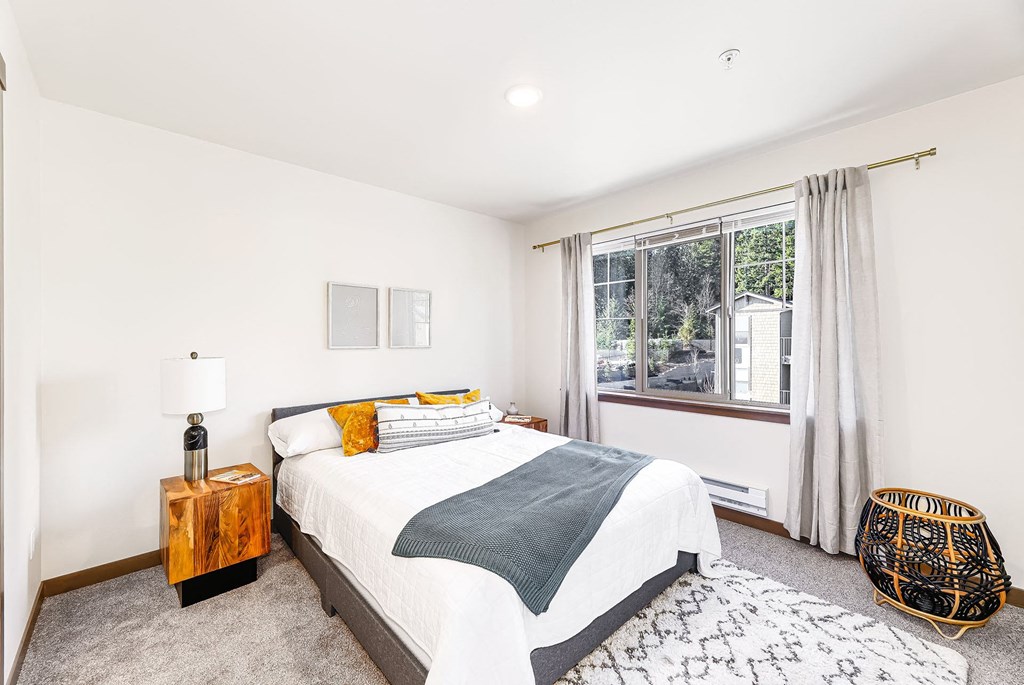 a bedroom with a bed and a large window