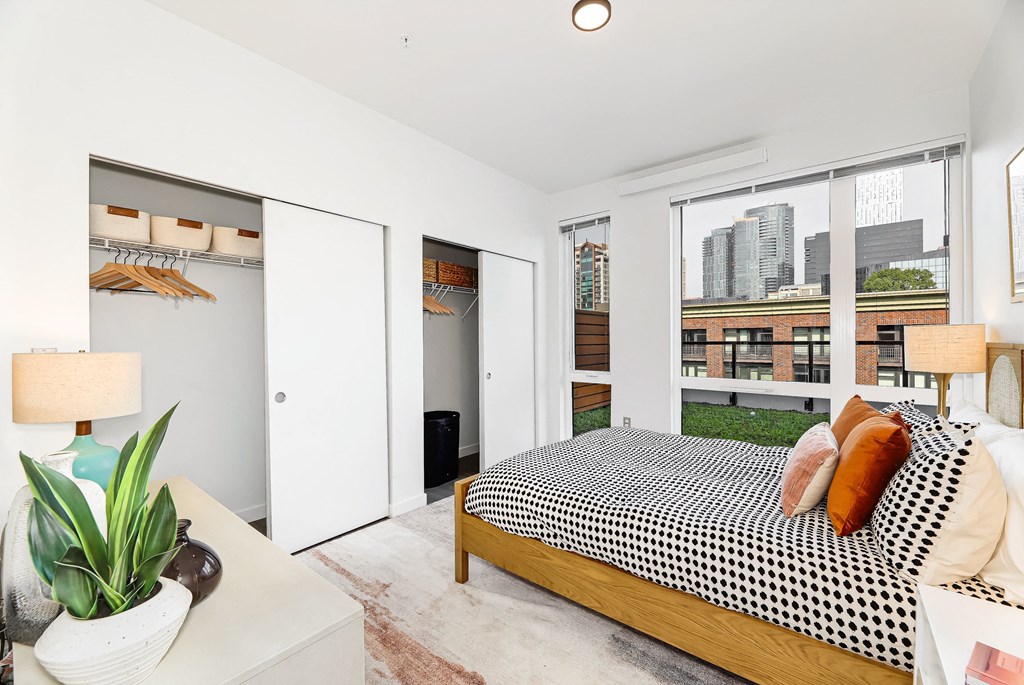 a bedroom with a bed and a large window