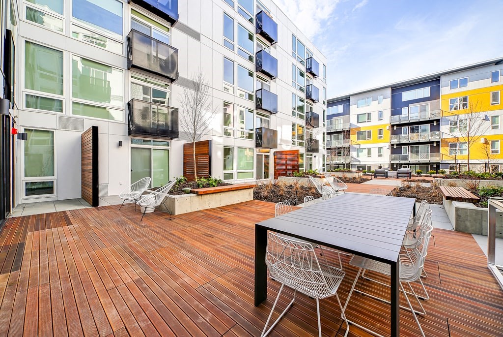 the patio of an apartment building with a table and chairs