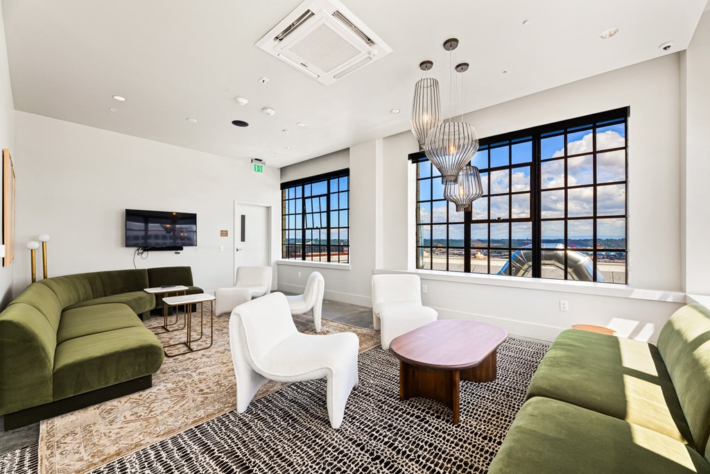 a living room with a green couch and white chairs