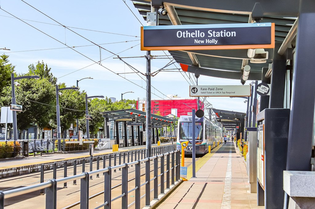 a train station with a train on the tracks and a sign