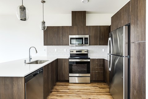 a modern kitchen with stainless steel appliances and wooden cabinets