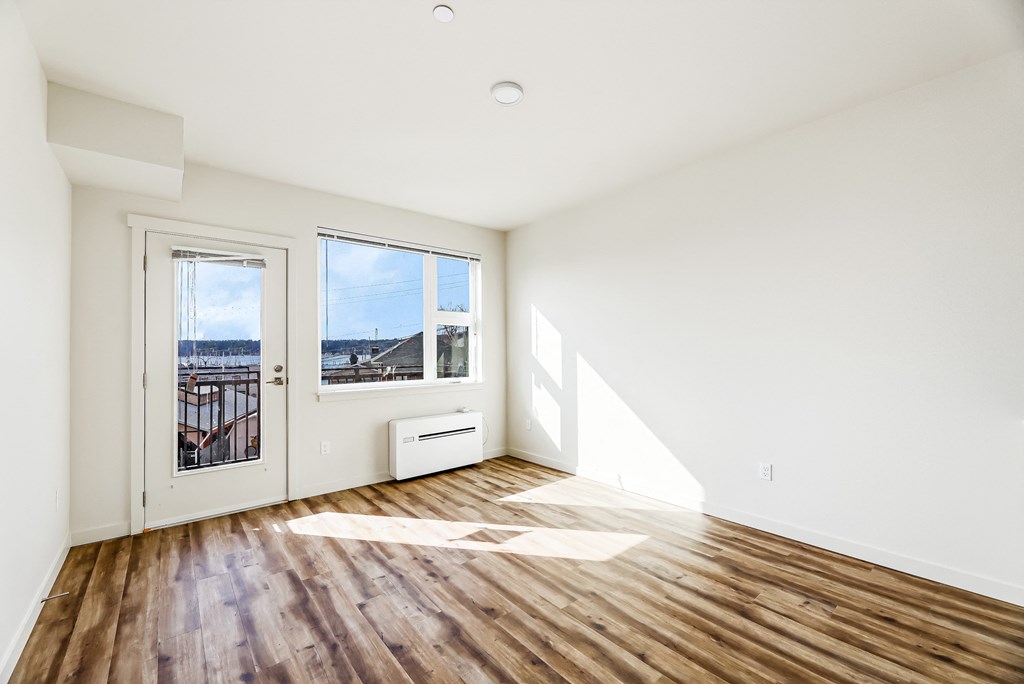 a bedroom with hardwood floors and white walls