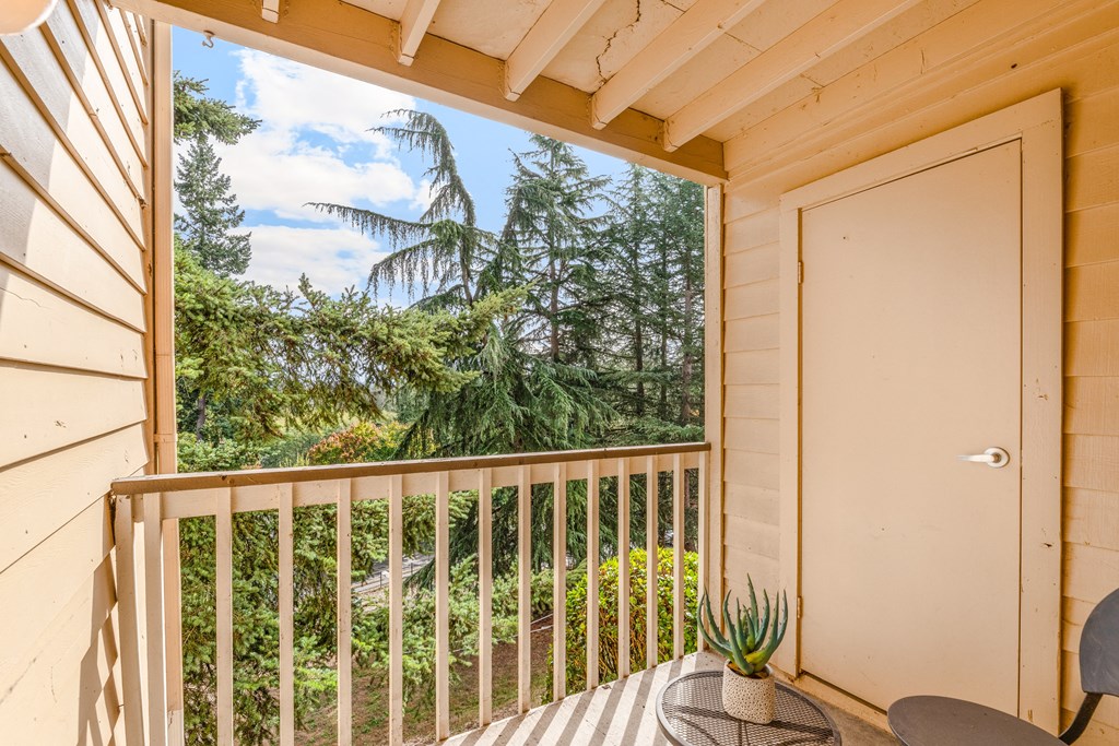 a porch with a table and a chair and a window