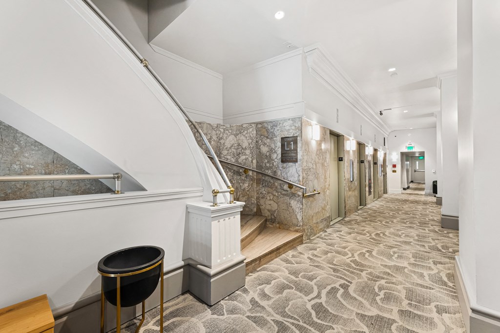 a view of a hallway with a staircase and a stool