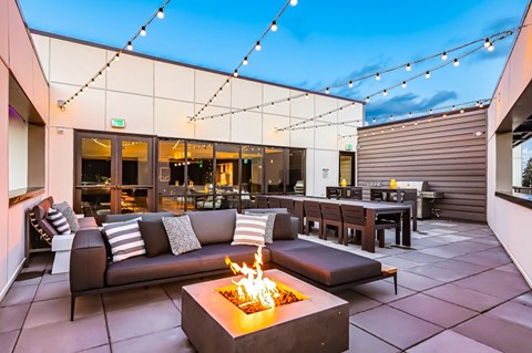 A modern outdoor seating area with a fire pit in the center.