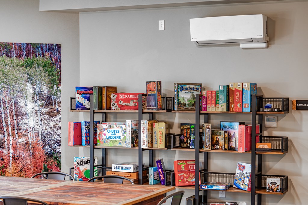 a bookshelf filled with books and a table and chairs