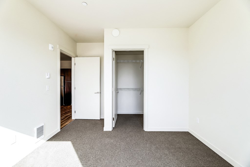 a bedroom with white walls and carpet