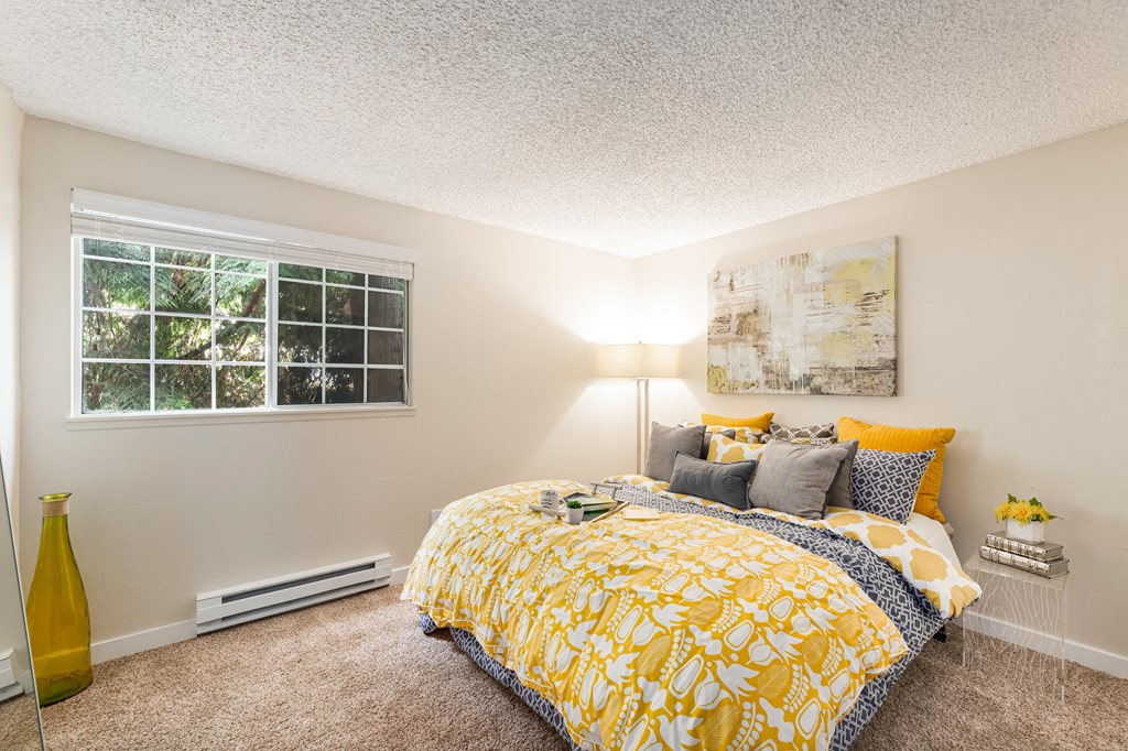 a bedroom with a yellow bed and a window