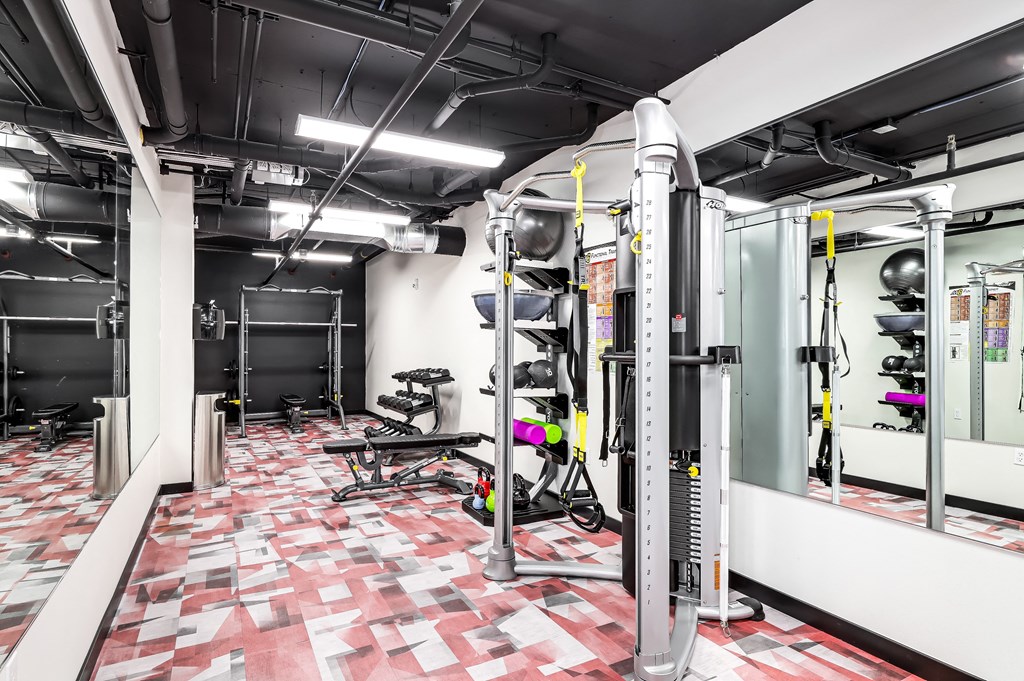 a gym with exercise equipment and a red and white tiled floor
