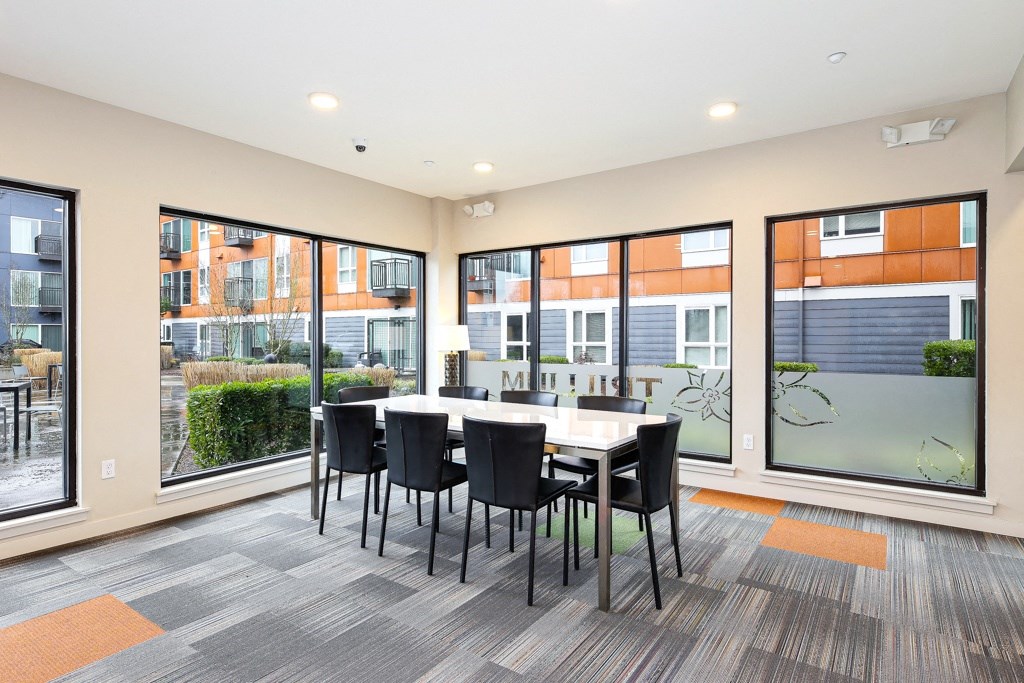 a dining room with large windows and a table and chairs