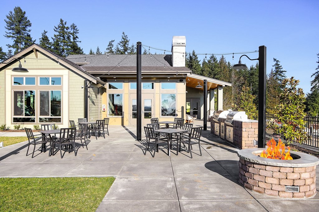 the patio of the residence has tables and chairs and a fire pit