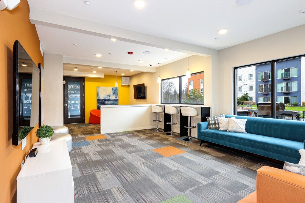 a living room with a blue couch and a table with chairs