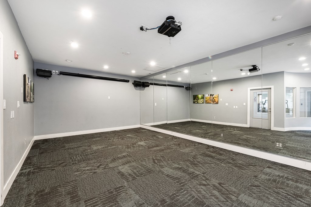 an empty room with mirrored walls and a ceiling fan