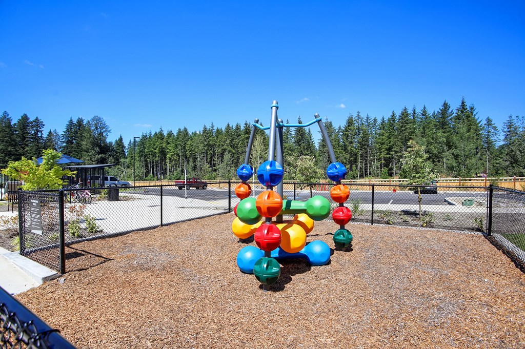 a playground with a swing set with colorful balloons on it