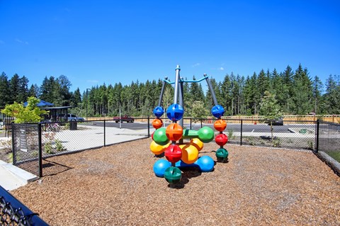 a playground with a swing set with colorful balloons on it