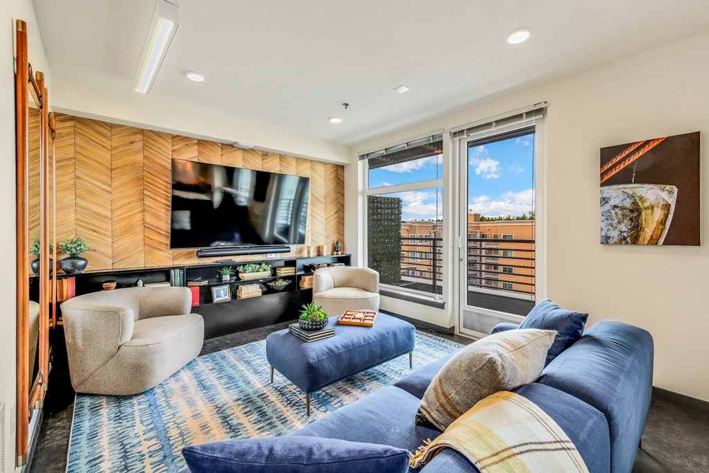 a living room with a blue rug and a couch and a television