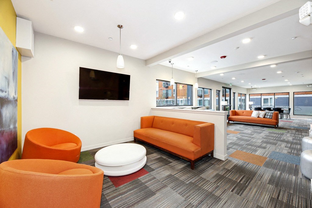 a living room with orange couches and a television