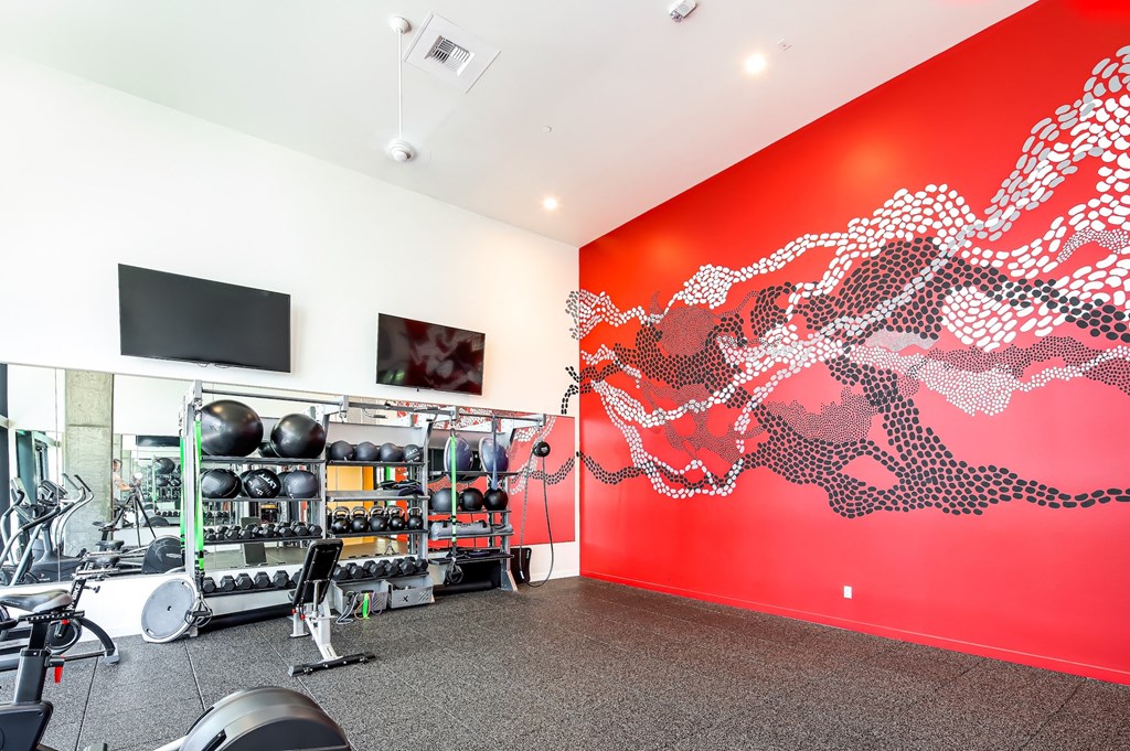 a workout room with a red wall and gym equipment