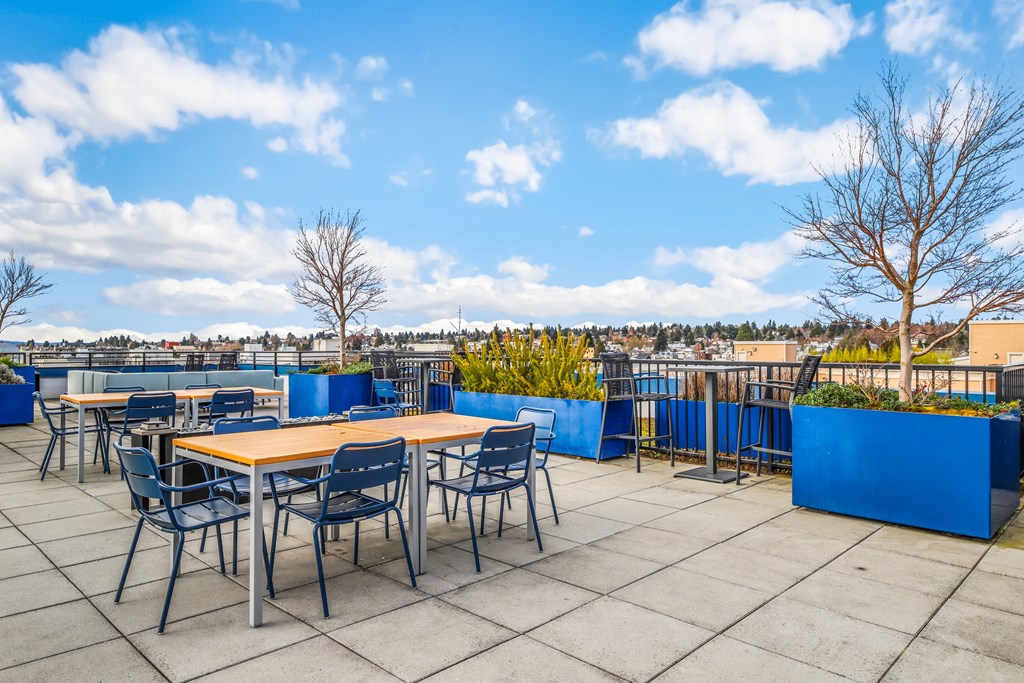 the rooftop patio of a restaurant with tables and chairs and a view of the city