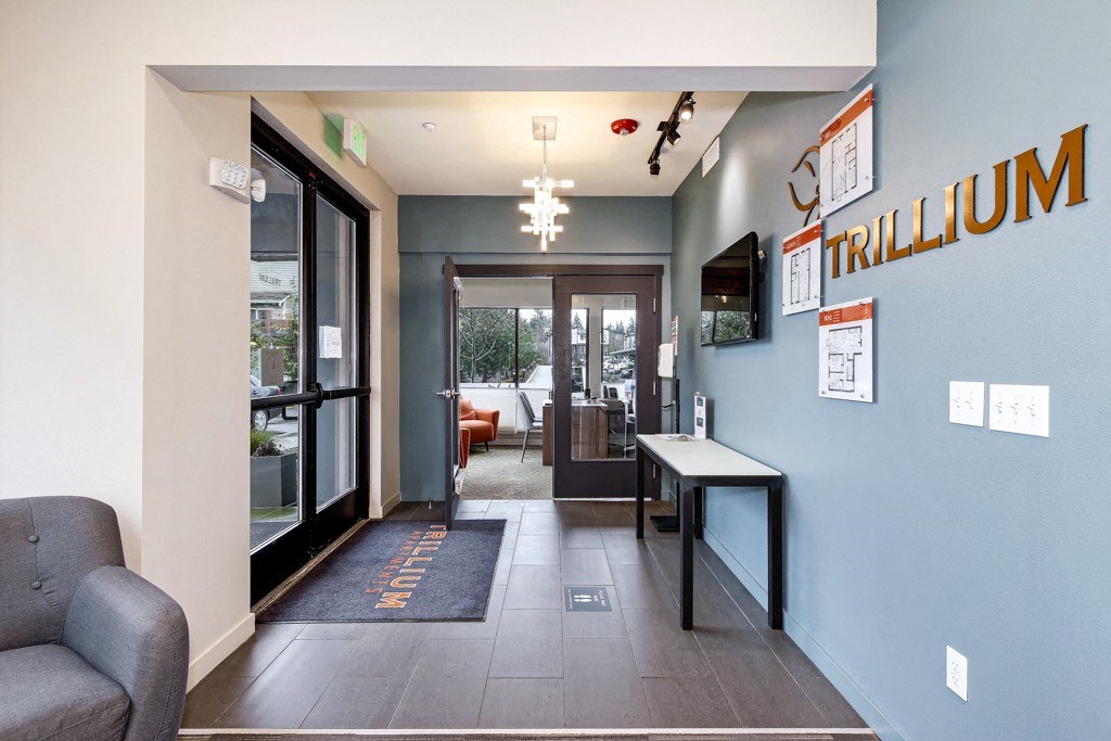 a corridor with a blue wall and a door to a hall way with a desk