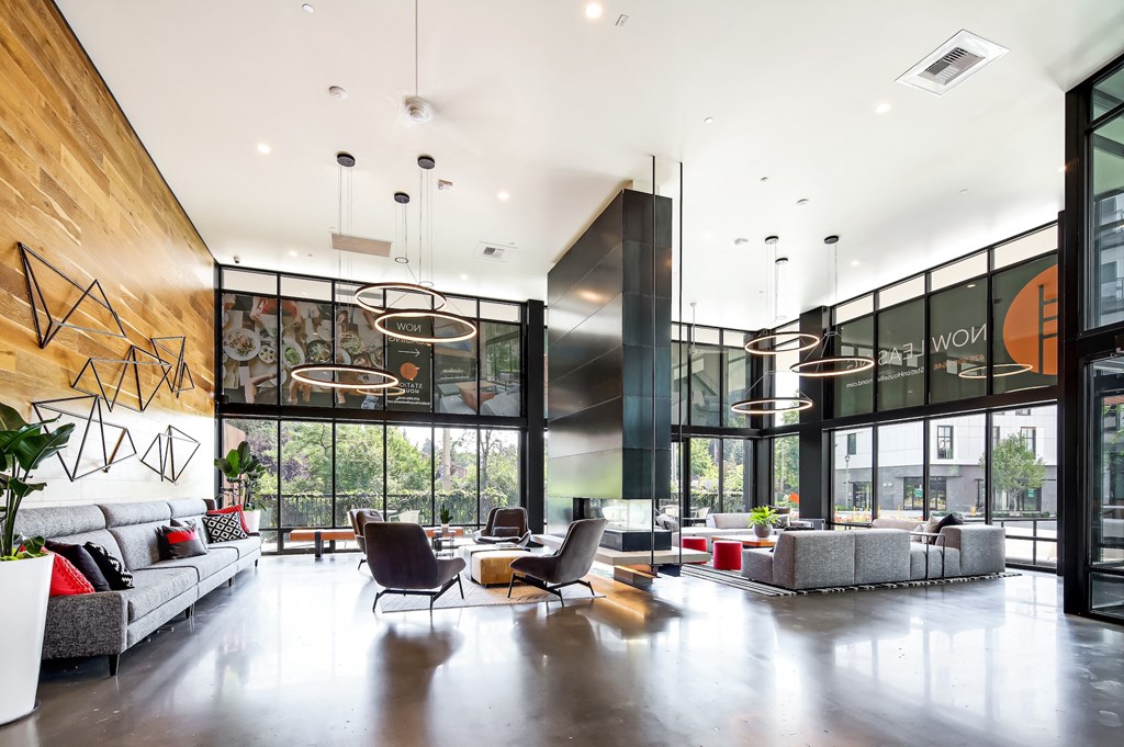 a living room with couches and chairs and large windows