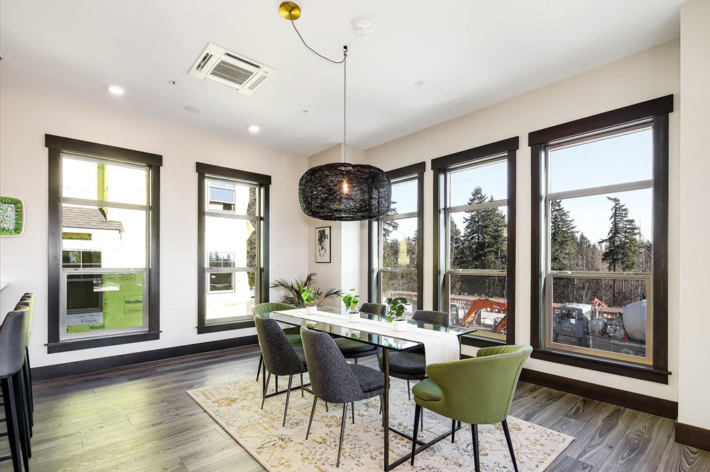 a dining room with a table and chairs and windows