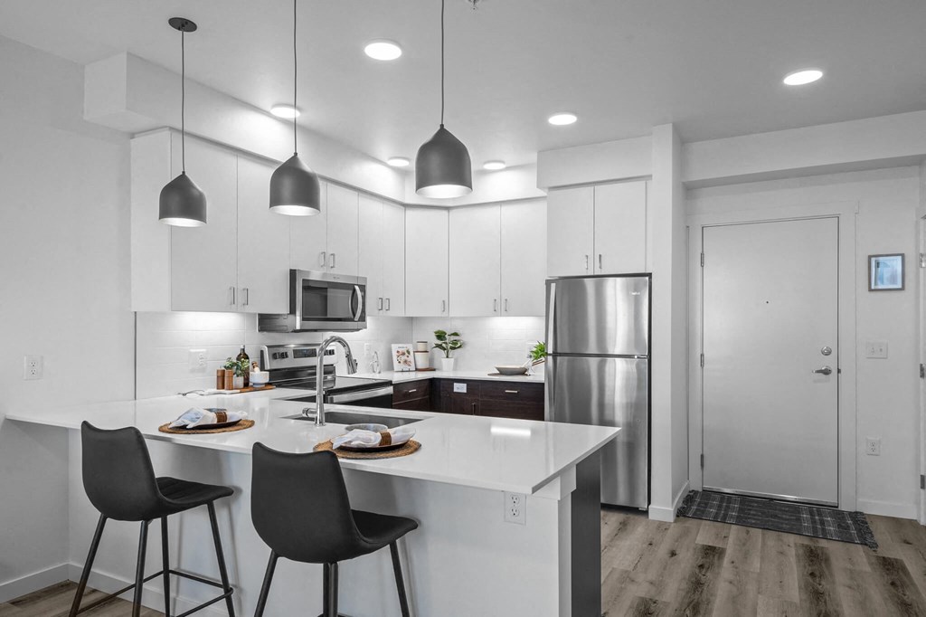 an open kitchen with white cabinets and a white counter top