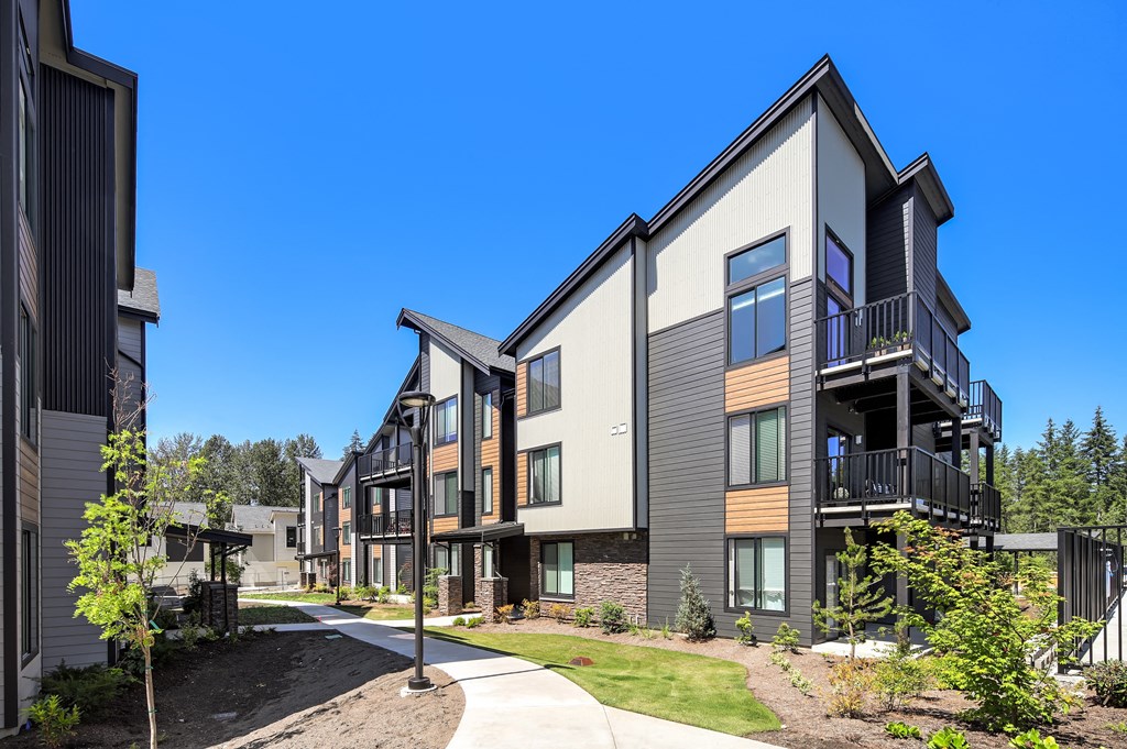 a row of apartment buildings with a sidewalk in front of them