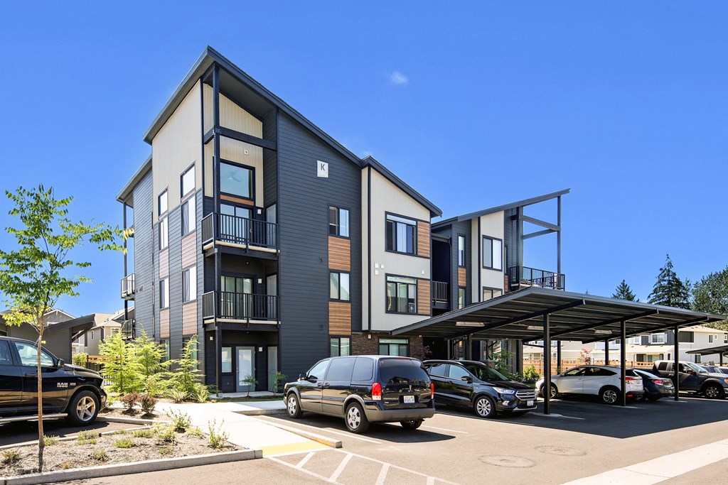 a new apartment building with cars parked in front of it