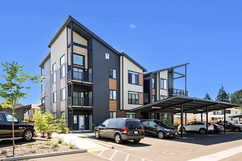 a new apartment building with cars parked in front of it