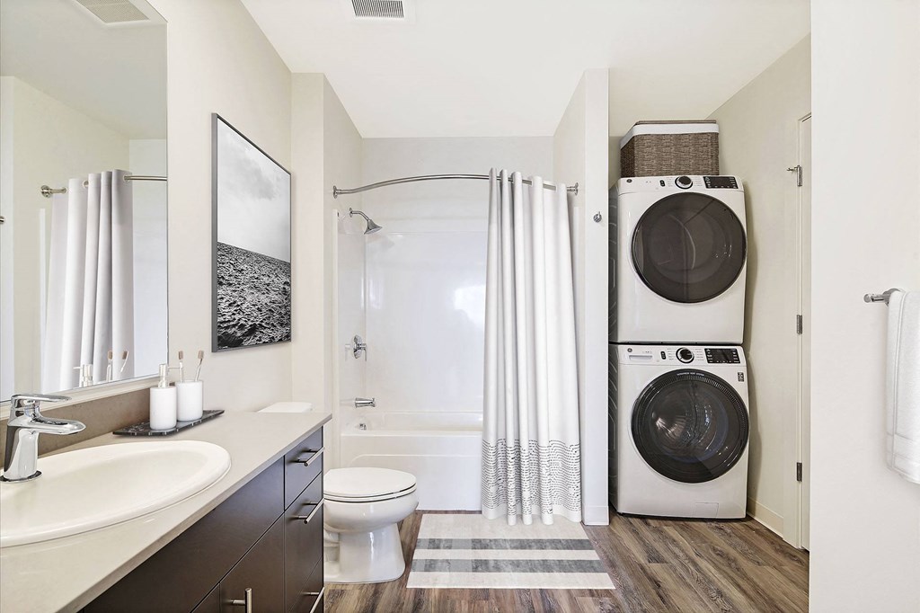 a bathroom with a washing machine and a toilet and a sink