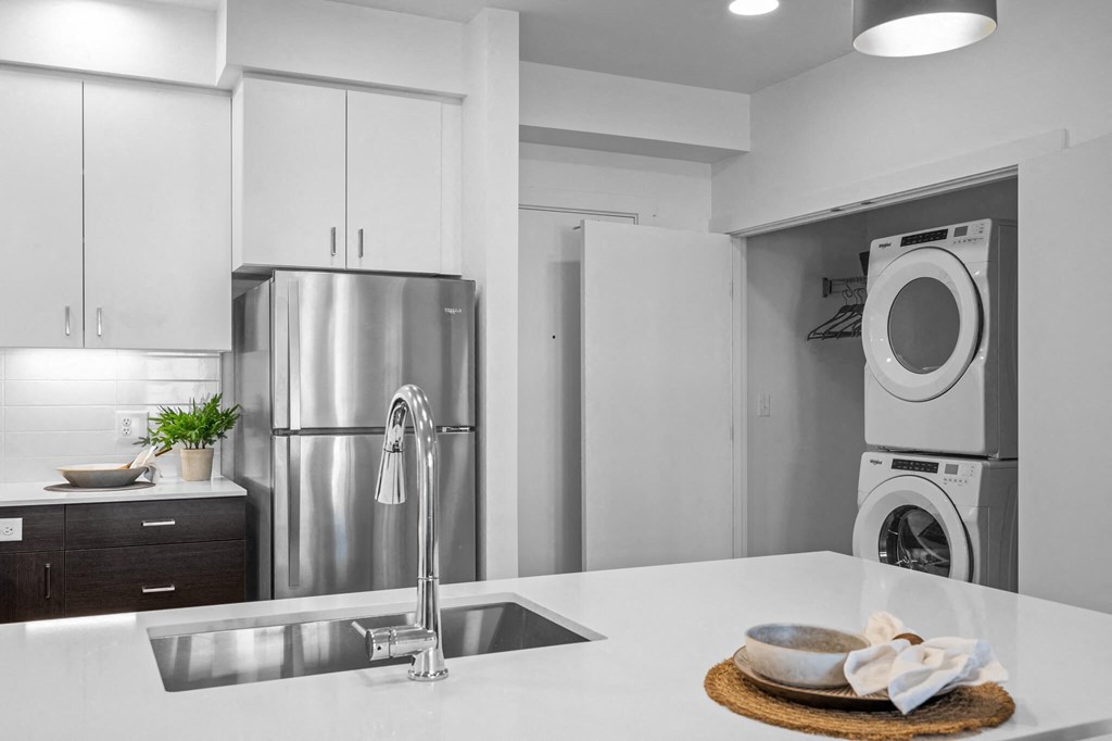 a white kitchen with a sink and a washing machine