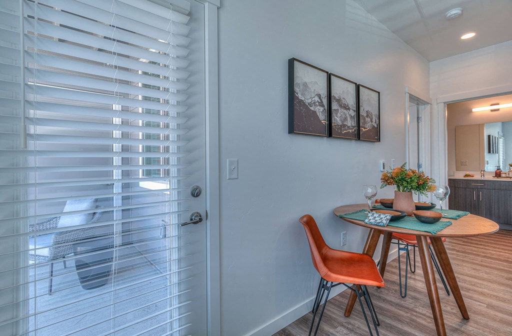 a dining room with a table and chairs next to a glass door